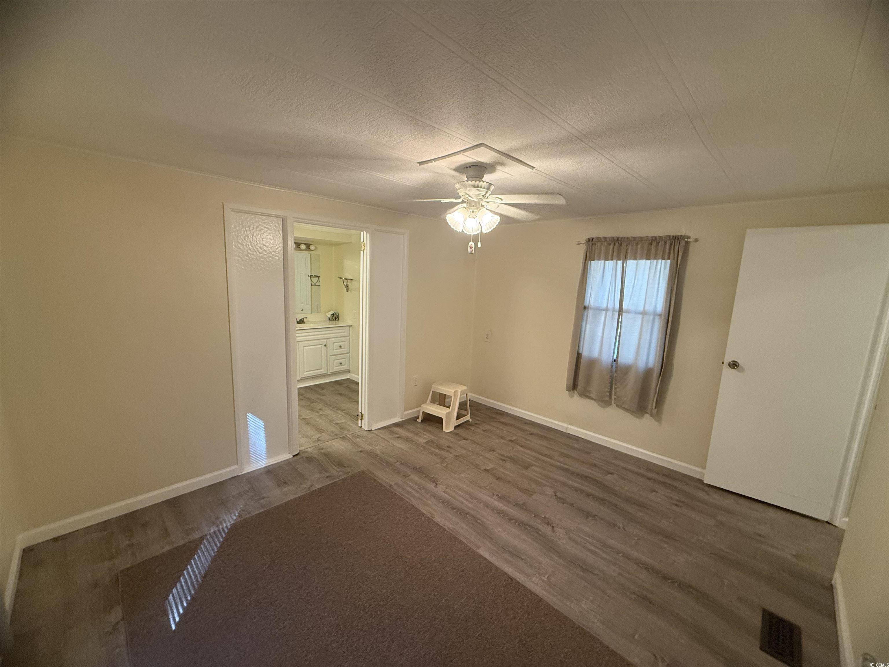 826 Jensen Drive North Murrells Inlet, SC 29576 - Photo 31 of 38 Unfurnished room featuring a textured ceiling, dark wood finished floors, and a ceiling fan