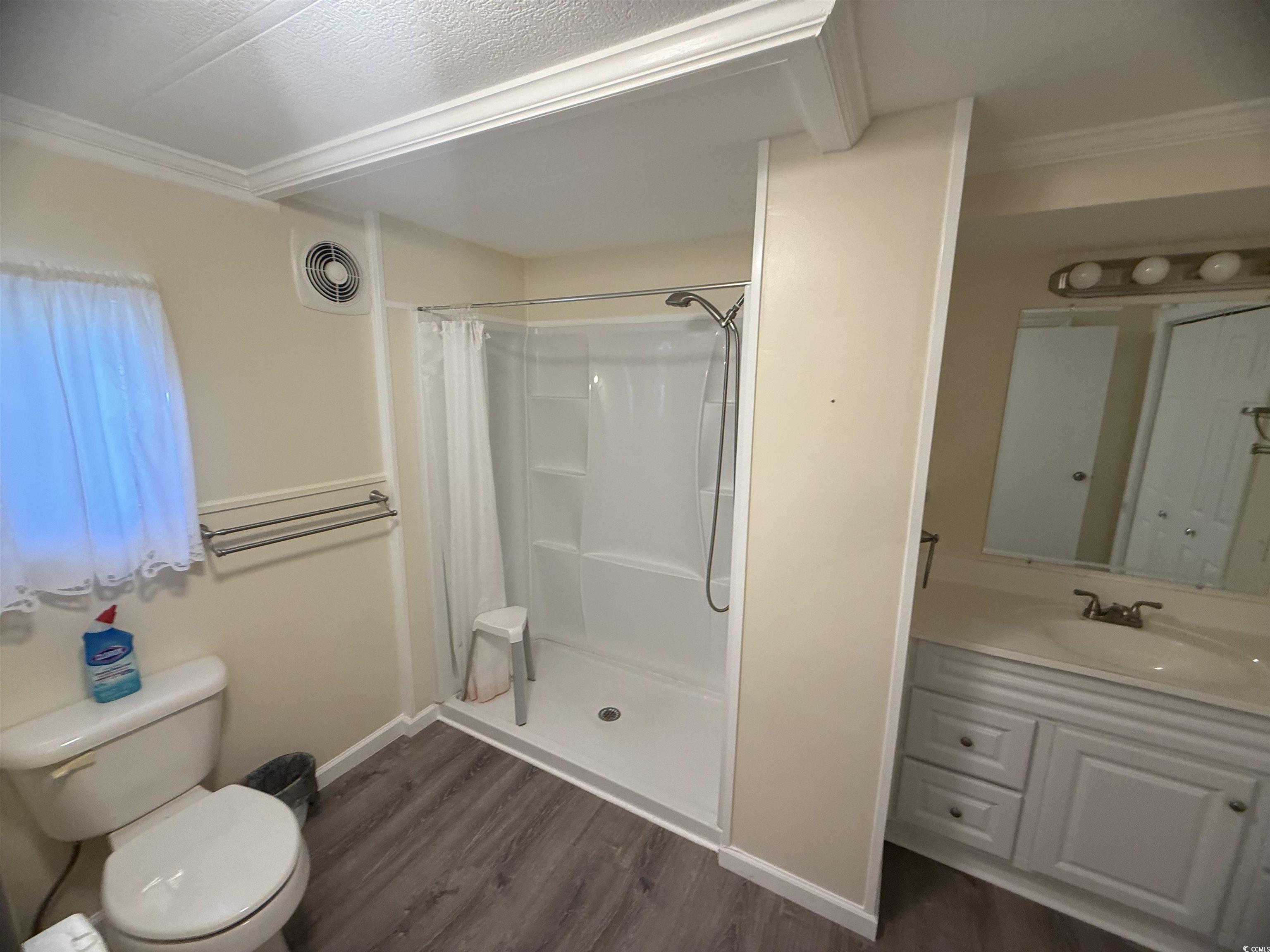 826 Jensen Drive North Murrells Inlet, SC 29576 - Photo 33 of 38 Bathroom featuring dark wood-type flooring, a shower stall, and vanity