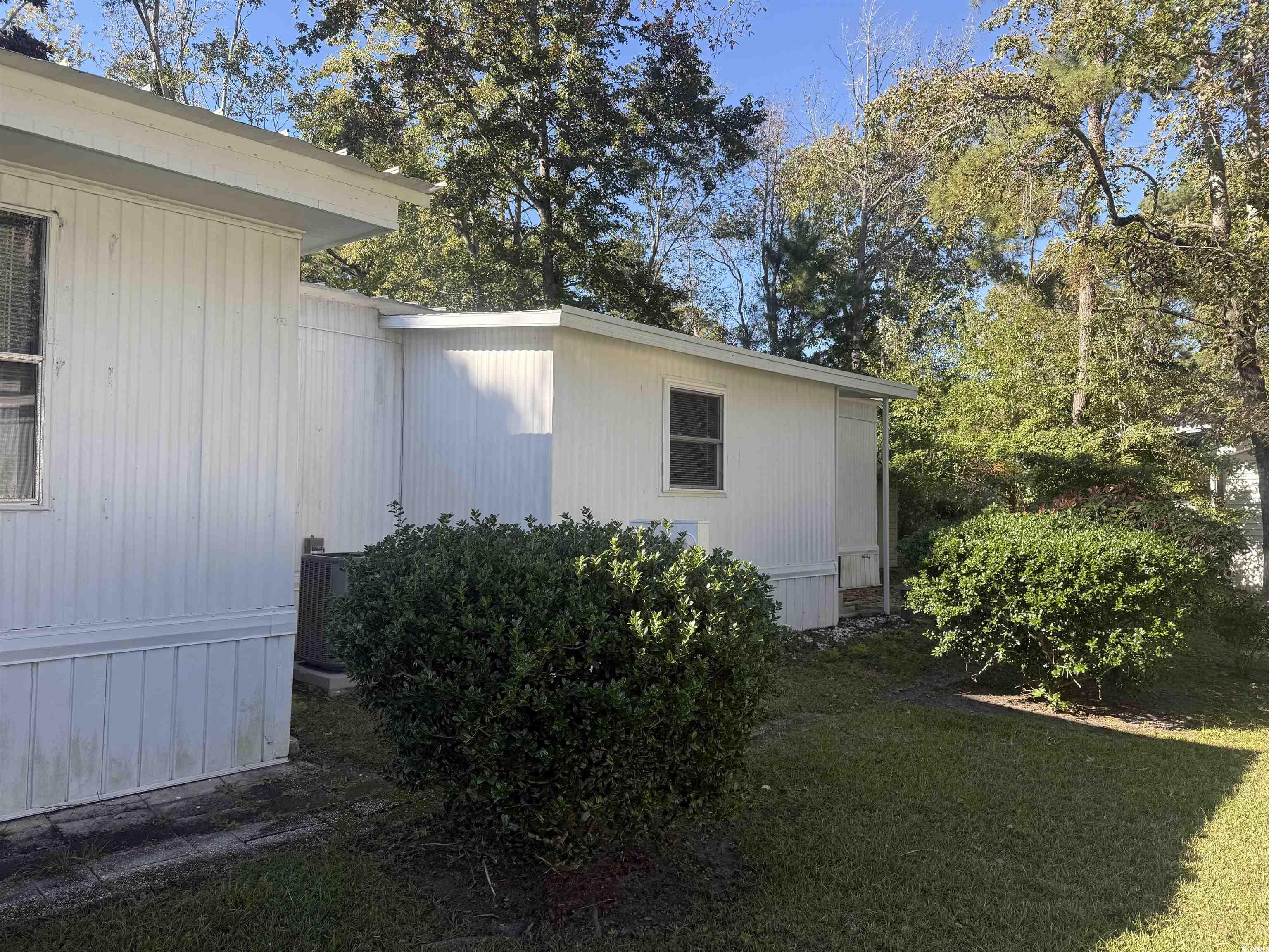 826 Jensen Drive North Murrells Inlet, SC 29576 - Photo 7 of 38 View of side of home featuring a lawn and a central AC unit