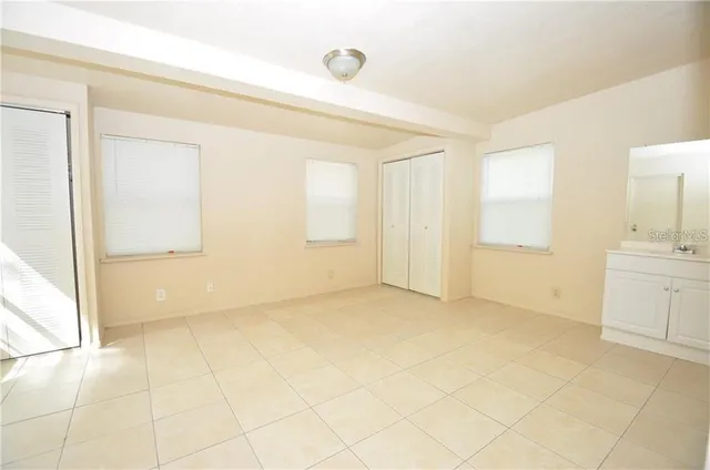 a view of an empty room with cabinet and a window