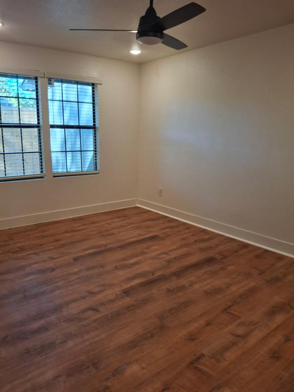 900 Chestnut Street Commerce, TX 75428 - Photo 10 of 19 an empty room with wooden floor and windows