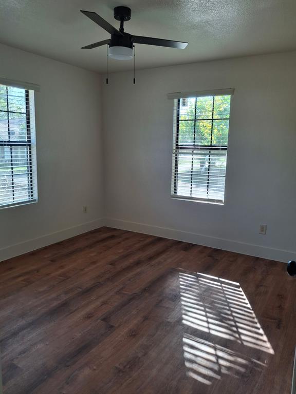 900 Chestnut Street Commerce, TX 75428 - Photo 15 of 19 an empty room with wooden floor and windows