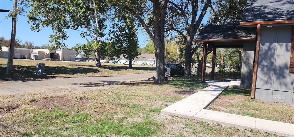 900 Chestnut Street Commerce, TX 75428 - Photo 17 of 19 a backyard of a house with barbeque oven and outdoor seating