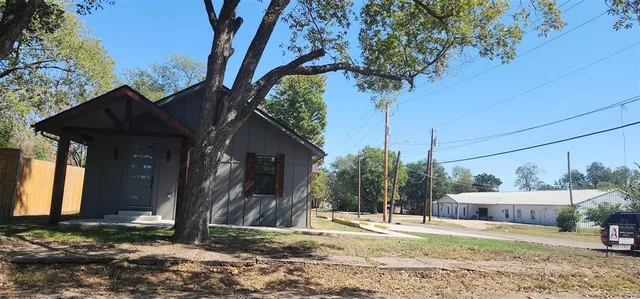 a backyard of a house with barbeque oven and outdoor seating