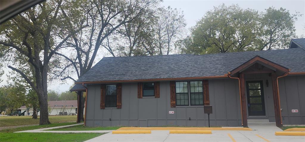 900 Chestnut Street Commerce, TX 75428 - Photo 2 of 19 a view of a house with pool and trees in the background