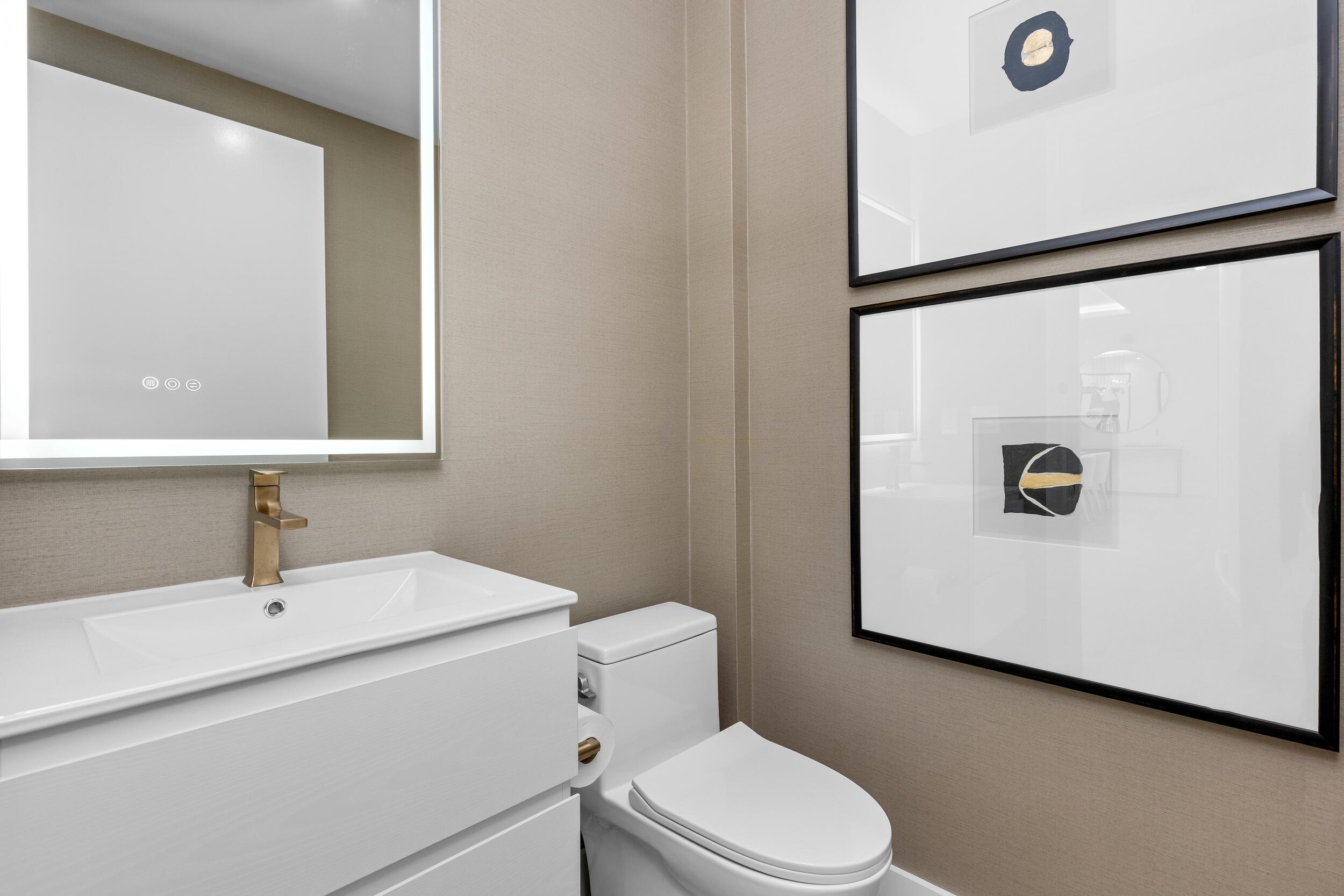 2494 South Ocean Boulevard, Unit C5 Boca Raton, FL 33432 - Photo 18 of 52 a bathroom with a toilet sink vanity and mirror