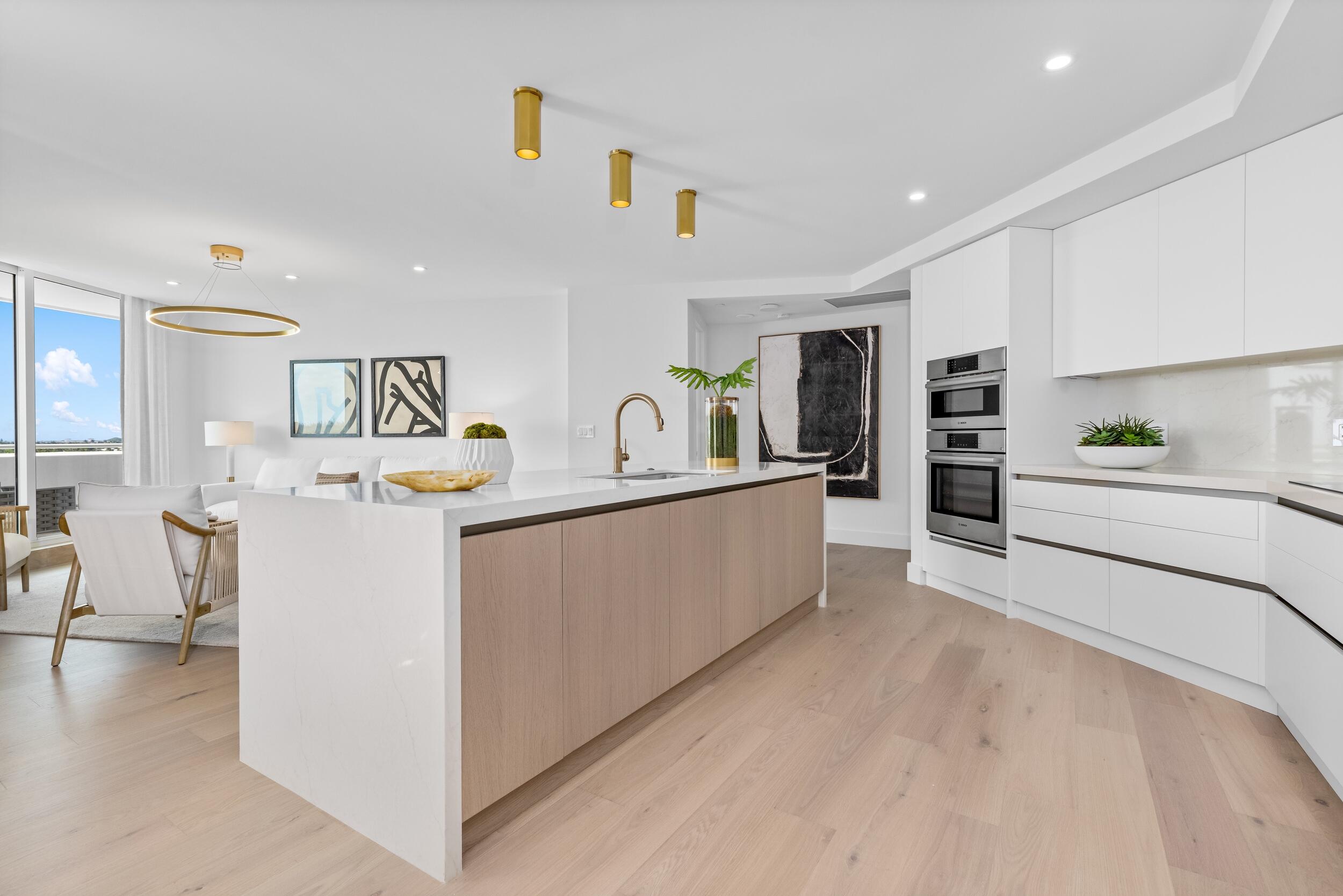 2494 South Ocean Boulevard, Unit C5 Boca Raton, FL 33432 - Photo 22 of 52 a large white kitchen with cabinets and a wooden floor