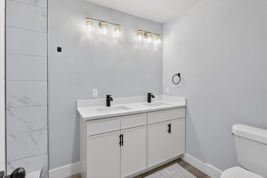 2005 Chestnut Road Carrollton, TX 75007 - Photo 29 of 35 a bathroom with a sink a toilet and mirror