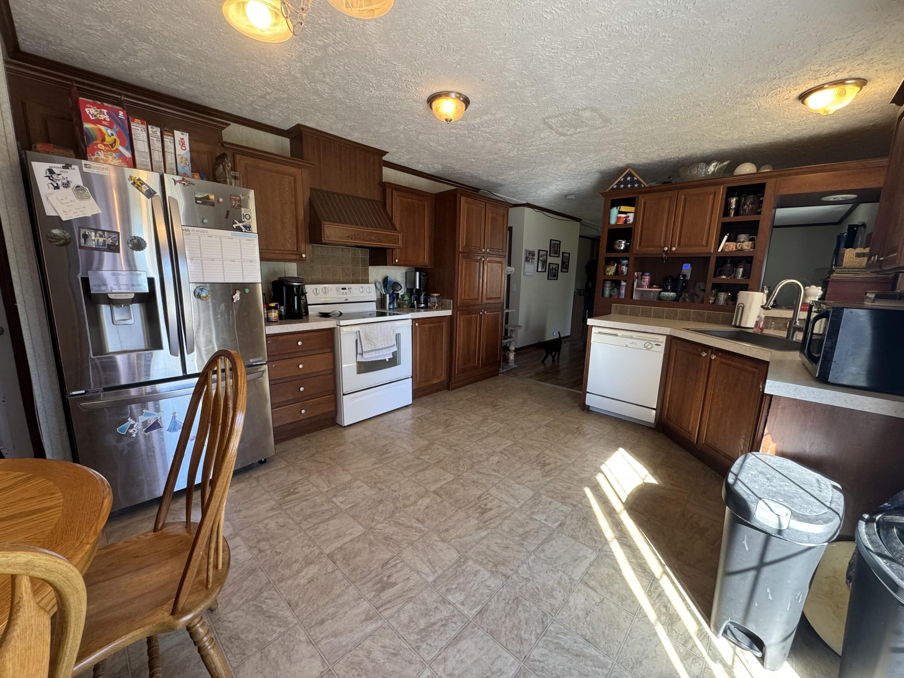 300 White Oak Road Boones Mill, VA 24065 - Photo 16 of 28 a kitchen with stainless steel appliances granite countertop a refrigerator a stove top oven a sink dishwasher and white cabinets with wooden floor