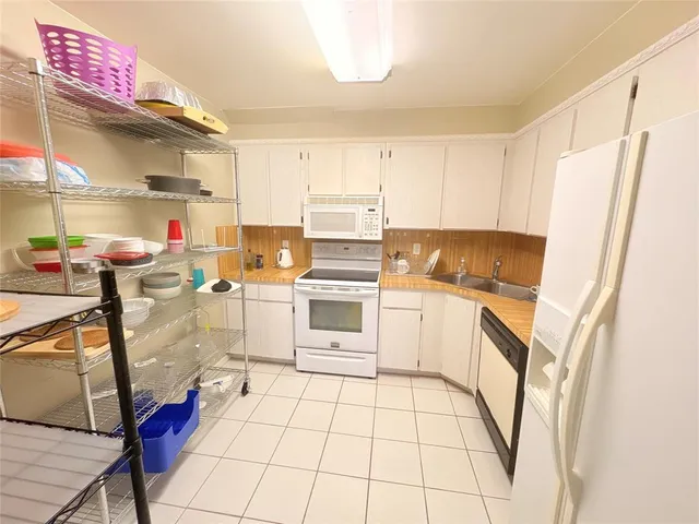 a kitchen with white cabinets and white appliances