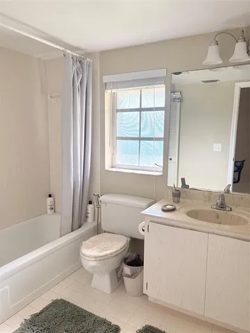a bathroom with a granite countertop sink toilet a large mirror a bathtub and shower