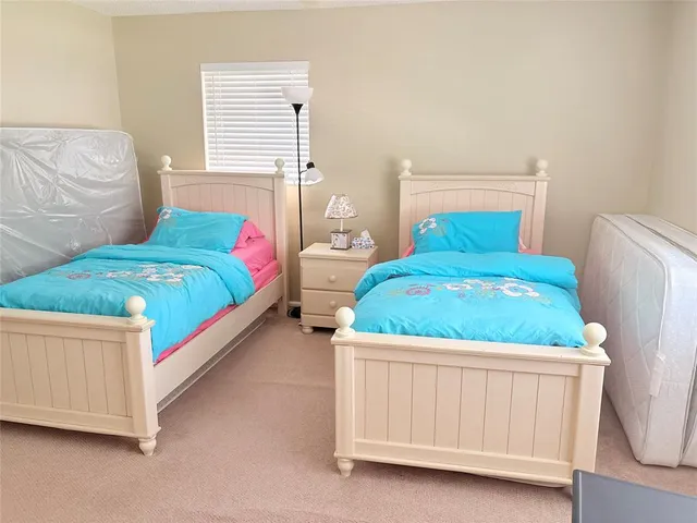 a bedroom with a bed a dresser and window