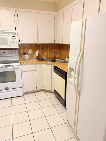 a kitchen with appliances cabinets and utility