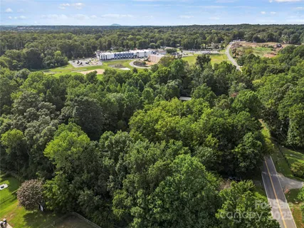 an aerial view of residential house with outdoor space and trees all around