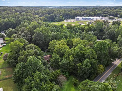 an aerial view of residential houses with outdoor space and trees