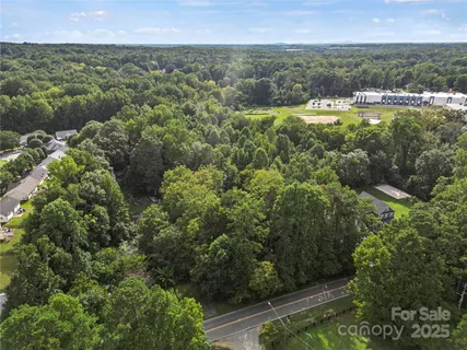 an aerial view of residential houses with outdoor space and trees