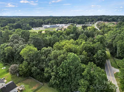 an aerial view of residential houses with outdoor space and trees