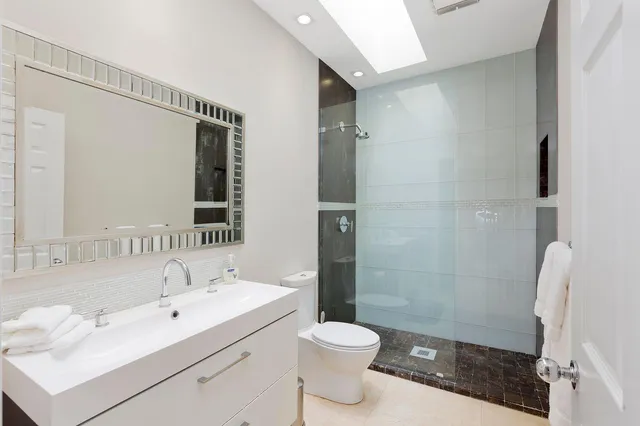 a bathroom with a sink a toilet and shower