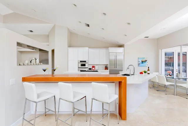 a large white kitchen with a table and chairs in it