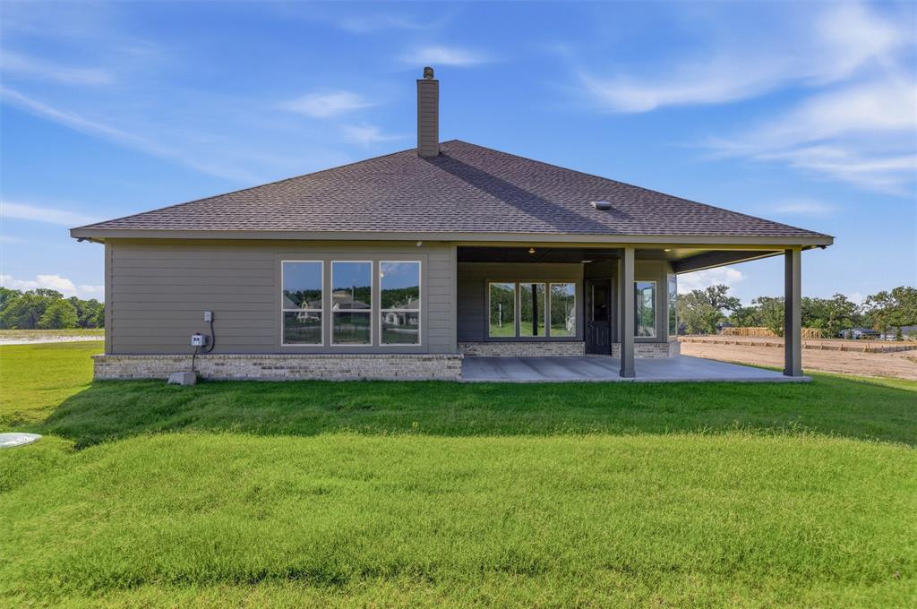 605 Tay Tay Way Springtown, TX 76082 - Photo 28 of 31 Rear exterior featuring a covered patio, dark gray siding, and a partial stone facade