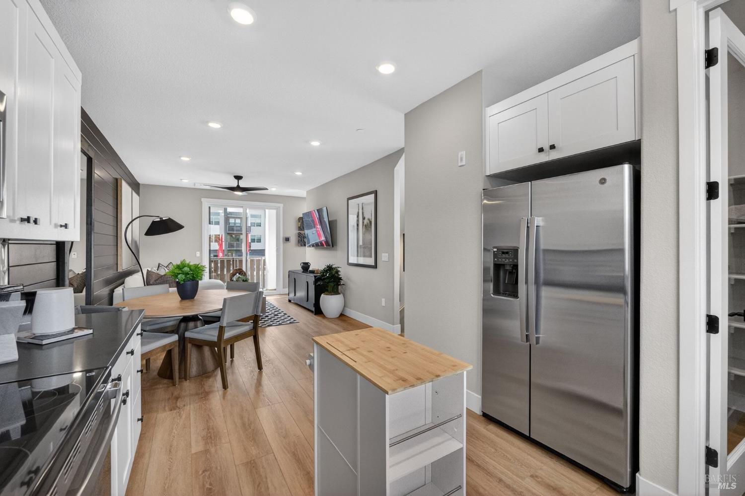 2811 Triad Place Livermore, CA 94551 - Photo 5 of 17 a kitchen with stainless steel appliances kitchen island granite countertop a refrigerator a stove and a dining table with wooden floor