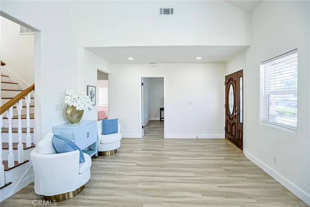 a living room with stainless steel appliances furniture a rug and a kitchen view