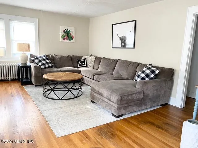 a living room with furniture and a wooden floor