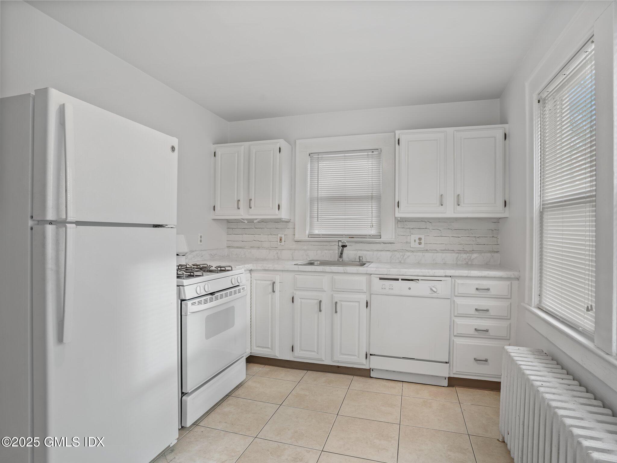 37 High Street, Unit 2 Greenwich, CT 06830 - Photo 10 of 23 a kitchen with white cabinets and white appliances