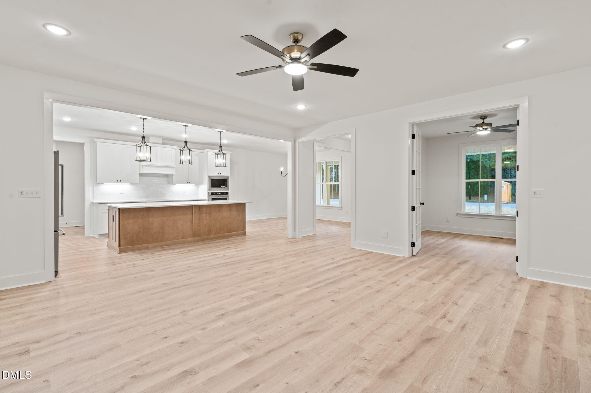 40 Beauview Way Zebulon, NC 27597 - Photo 19 of 52 a view of kitchen and empty room with wooden floor
