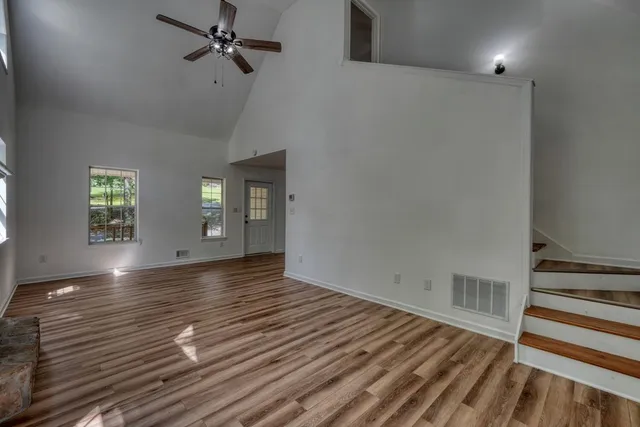 an empty room with windows and fireplace