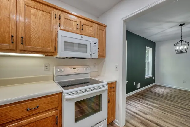 a view of empty room with wooden floor and window