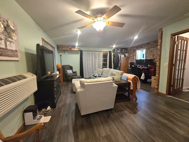 a living room with furniture a dining table and wooden floor