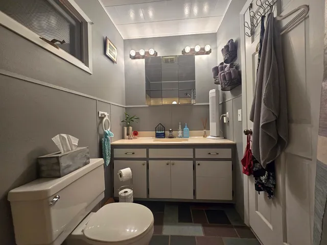 a bathroom with a toilet sink and mirror
