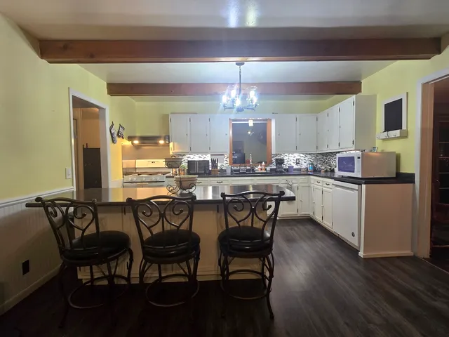 a kitchen with a dining table chairs and white cabinets