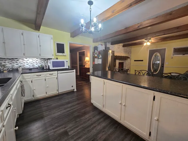 a large kitchen with cabinets a sink and dishwasher a stove with wooden floor