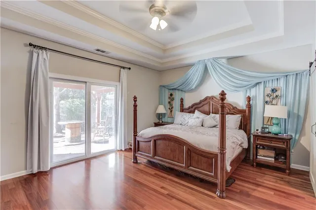 a bedroom with a bed a window and wooden floor