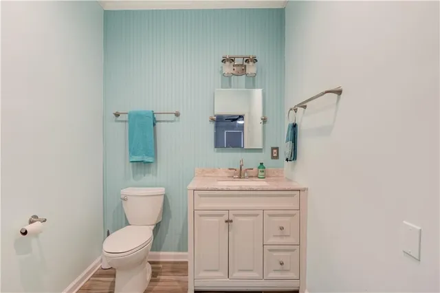 a bathroom with a toilet sink vanity and mirror