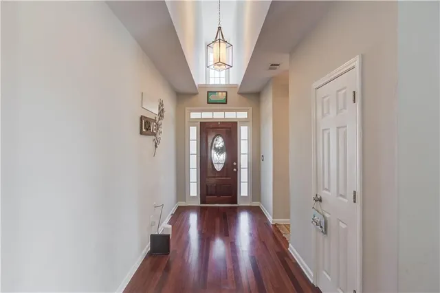 a view of a hallway with wooden floor and staircase