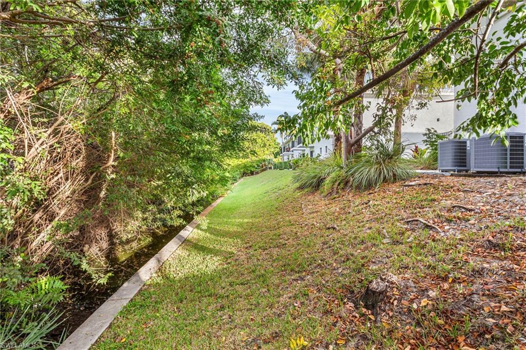 27682 Imperial River Road, Unit CH1 Bonita Springs, FL 34134 - Photo 15 of 24 a view of a yard with large trees