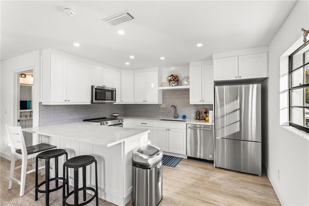 27682 Imperial River Road, Unit CH1 Bonita Springs, FL 34134 - Photo 5 of 24 a kitchen with stainless steel appliances granite countertop white cabinets a sink a stove a refrigerator and island