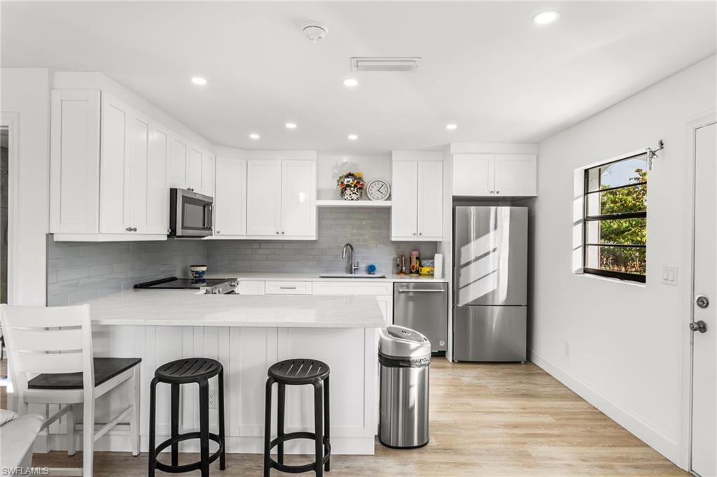 27682 Imperial River Road, Unit CH1 Bonita Springs, FL 34134 - Photo 6 of 24 a kitchen with stainless steel appliances granite countertop a refrigerator and a stove top oven