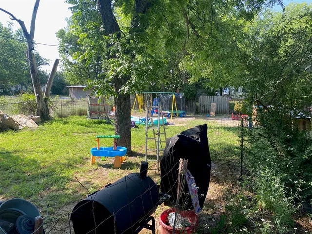 a view of a chairs and backyard with a barbeque grill and a small yard