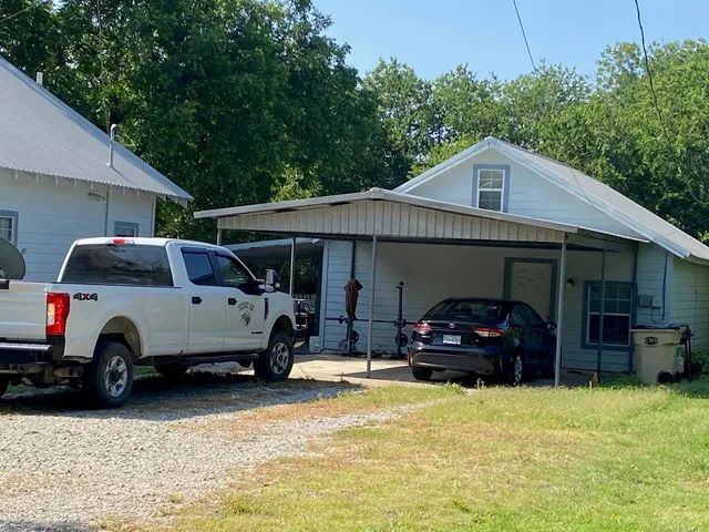 a front view of a house with cars parked