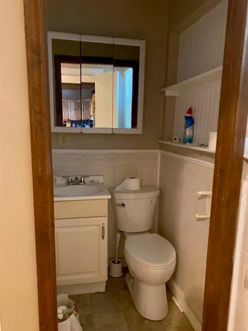 a bedroom with a bed and a lamp on the dresser