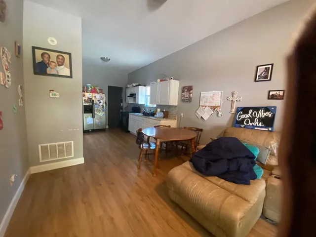 a living room with furniture and a wooden floor