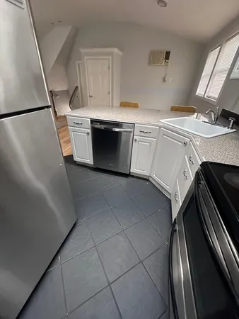 a kitchen with granite countertop white cabinets and stainless steel appliances