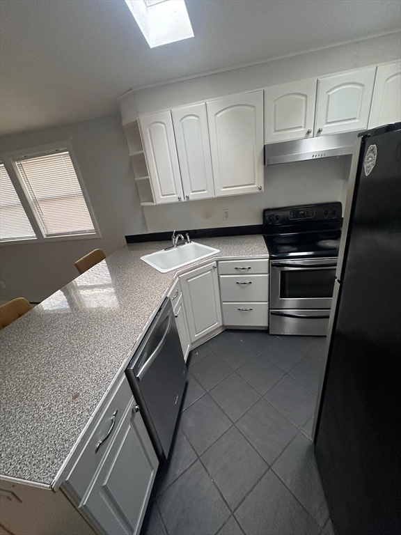 1295 Millbury Street, Unit B Worcester, MA 01607 - Photo 12 of 28 a kitchen with granite countertop white cabinets and stainless steel appliances