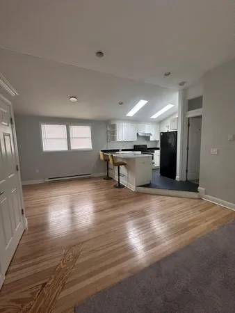 a view of kitchen with refrigerator stove and wooden floor