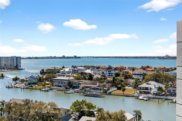 a view of a ocean with boats and trees in the background