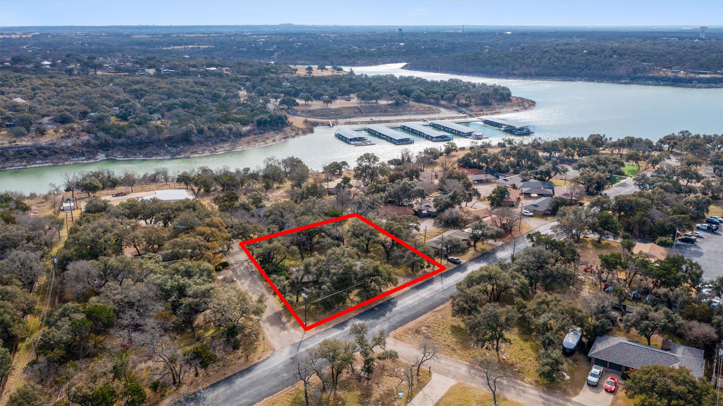 Aerial view of property and surrounding area with a large body of water and property parcel outlined